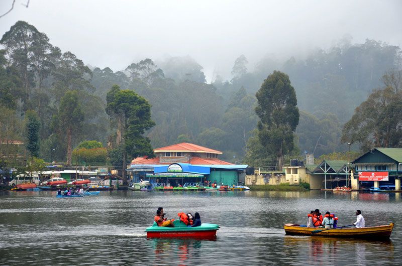 Boats on Kodaikanal Lake surrounded by misty forest